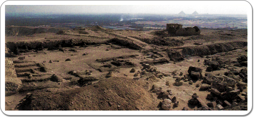 A view on the remains of the mortuary temple, with two of the pyramids of Giza in the background.